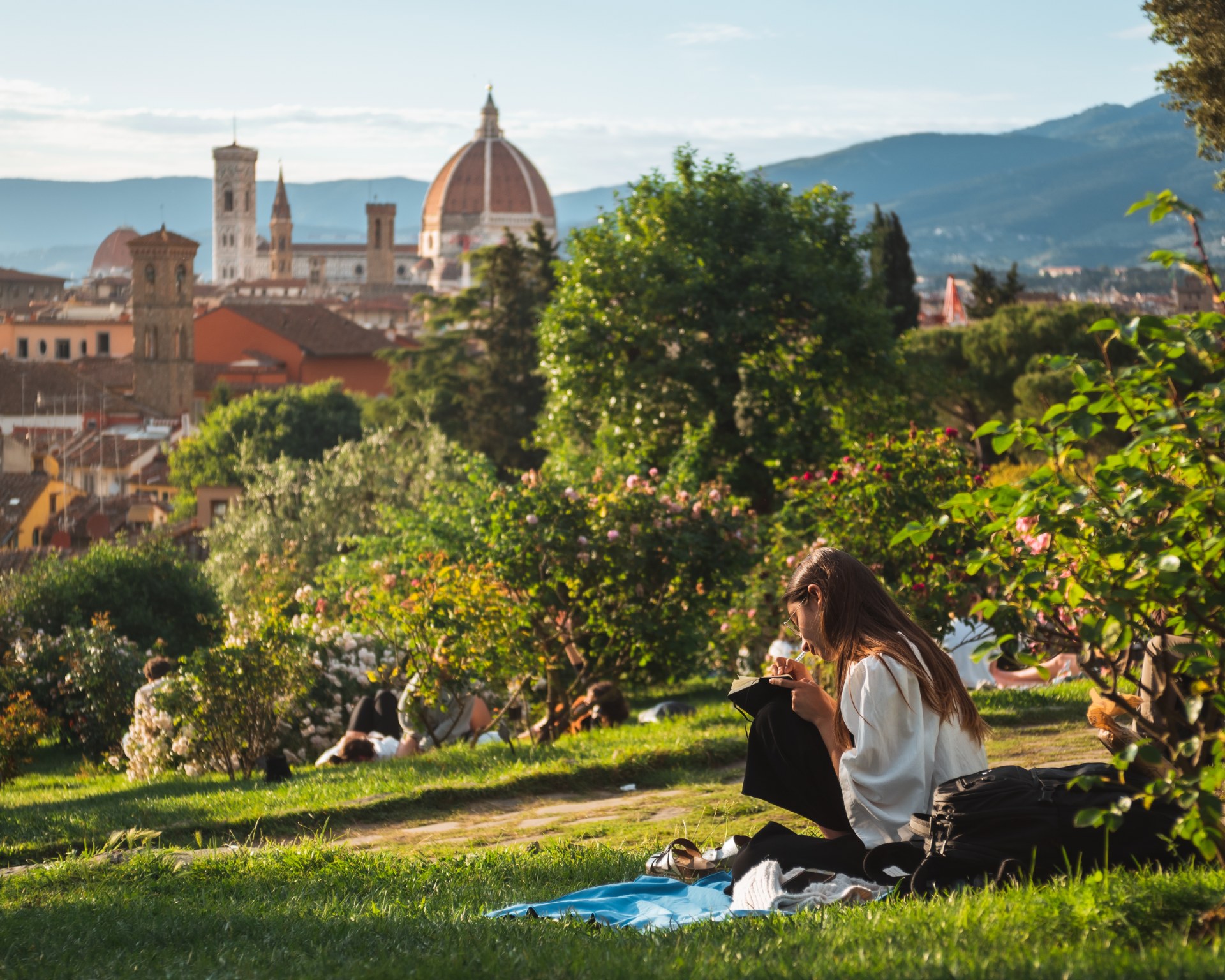 Ragazza che legge sul prato con vista su Firenze